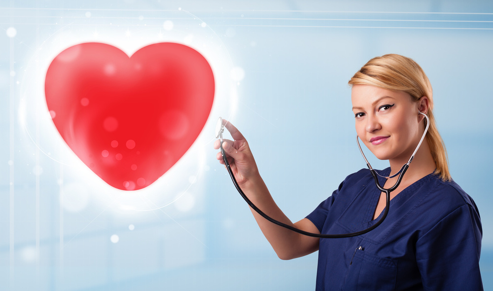 Pretty young nurse healing a red heart